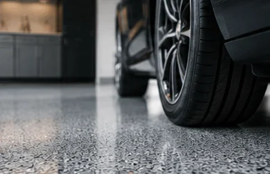 Car tire resting on a glossy flake-coated garage floor