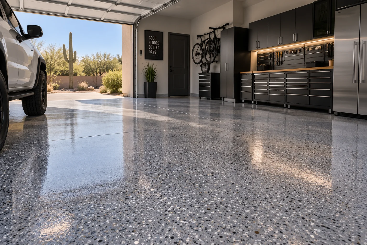 Sunlit garage with a glossy grey flake floor, black cabinets and a pickup truck
